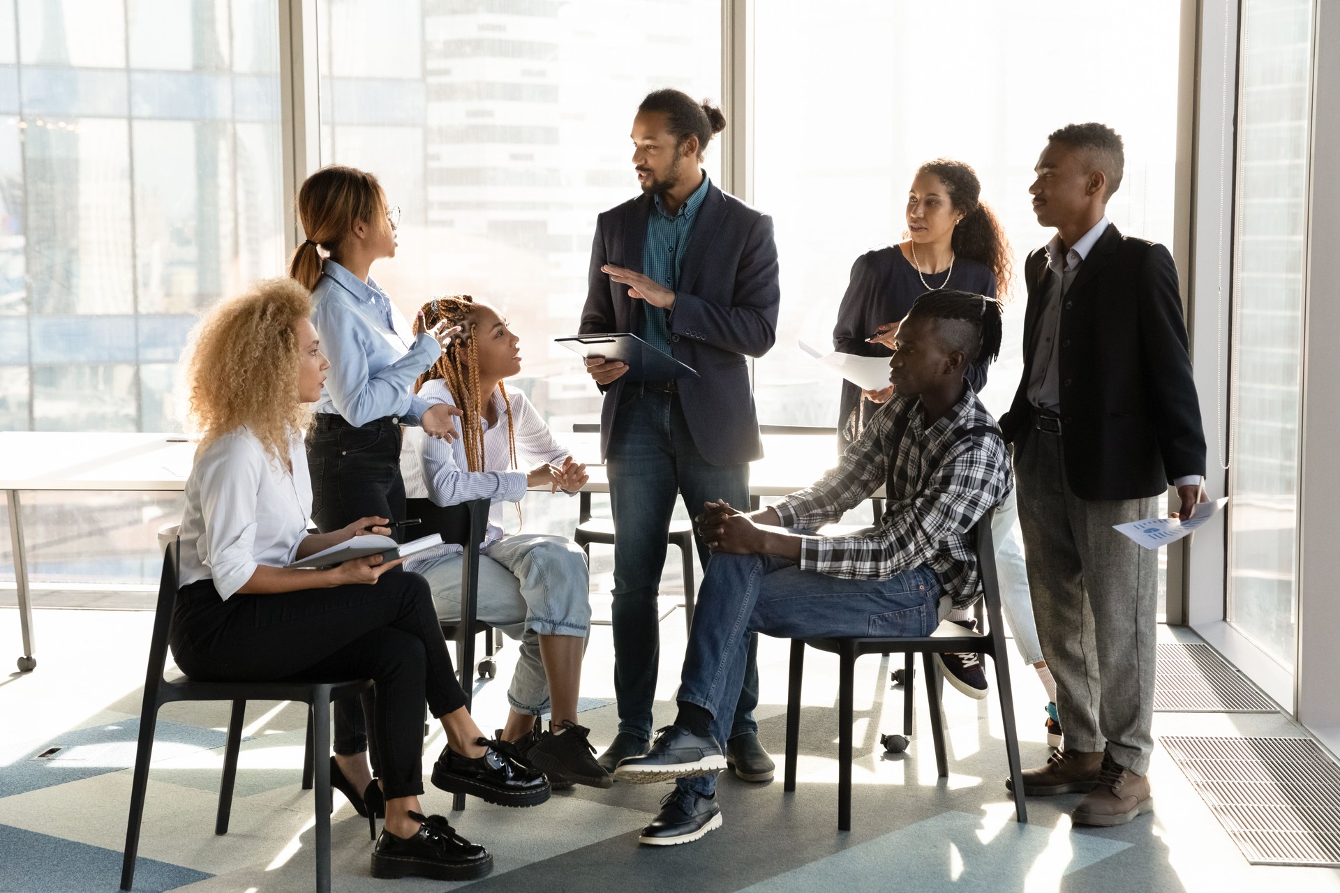 African American businessman mentor training diverse employees team at briefing